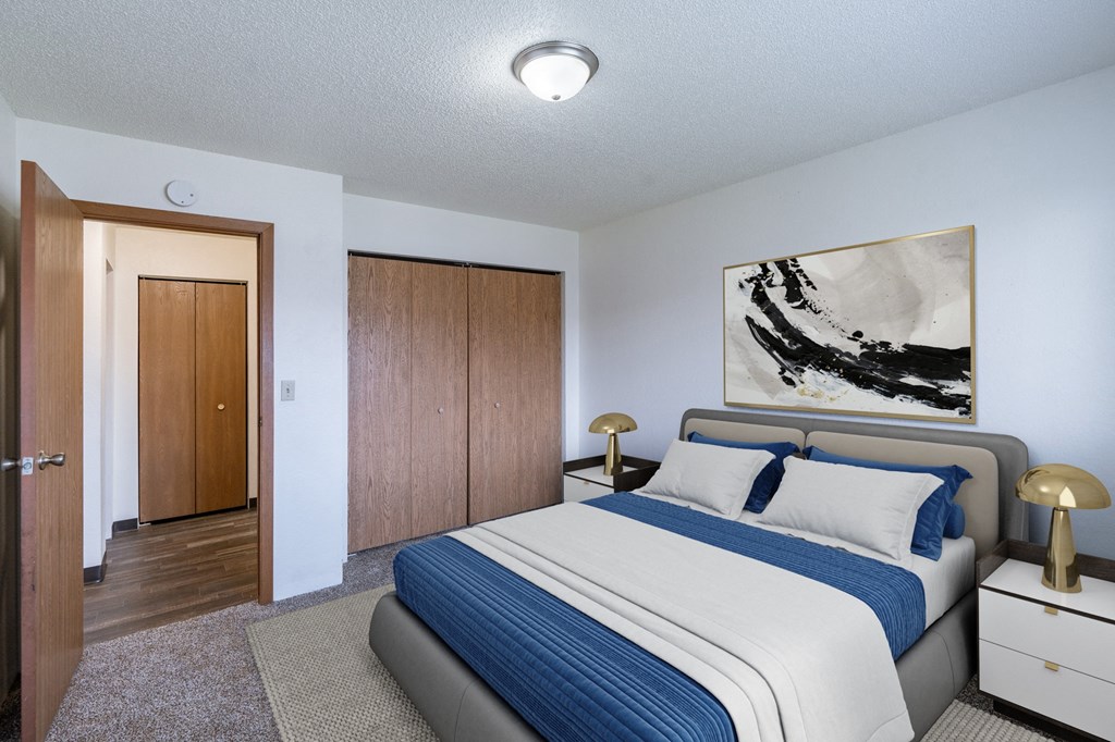 a bedroom with a bed and a closet. Fargo, ND Place One Apartments