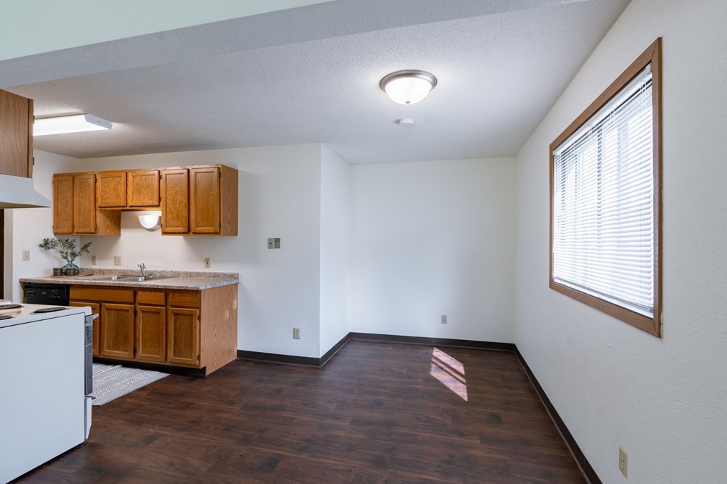the view of a kitchen and living room with a large window. Fargo, ND Place One Apartments