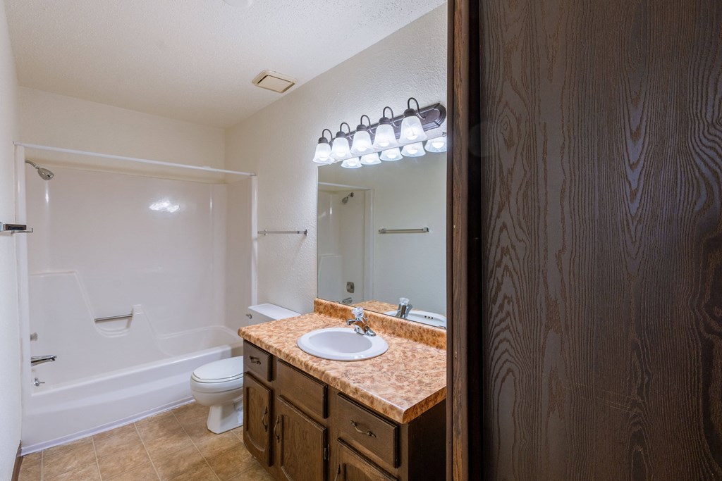 a bathroom with a sink and a toilet and a mirror. Fargo, ND Plumtree Apartments