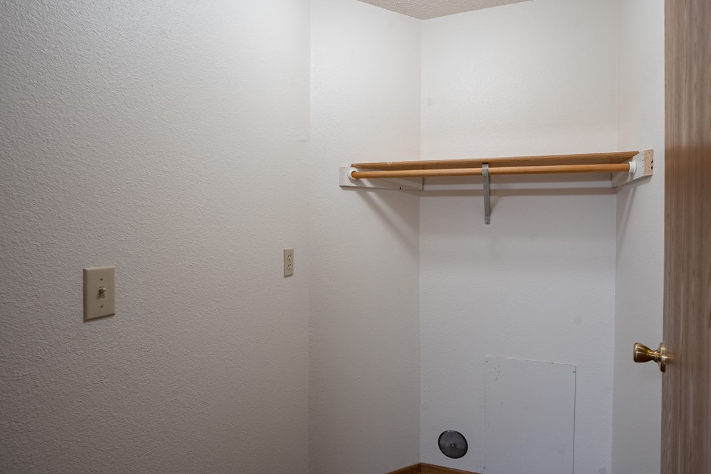 a bathroom with a shower and a hanging rail on the wall
