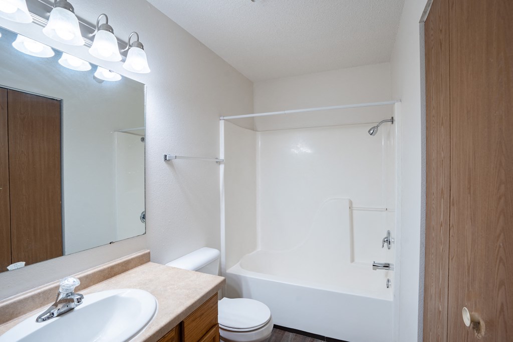 a bathroom with a shower and a sink and a mirror. Fargo, ND  Prairie Park Apartments