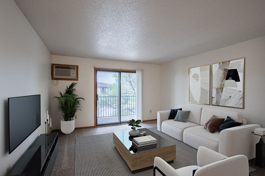a living room with a white couch and a television. Fargo, ND Prairie Park Apartments