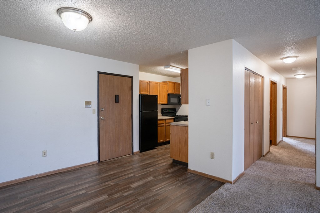 a dining room and kitchen with wood flooring and white walls. Fargo, ND  Prairie Park Apartments