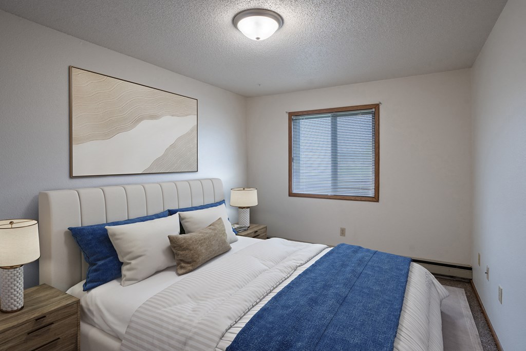 Fargo, ND Prairie Park Apartments | Bedroom a bedroom with a large bed and a window. Fargo, ND Prairie Park Apartments