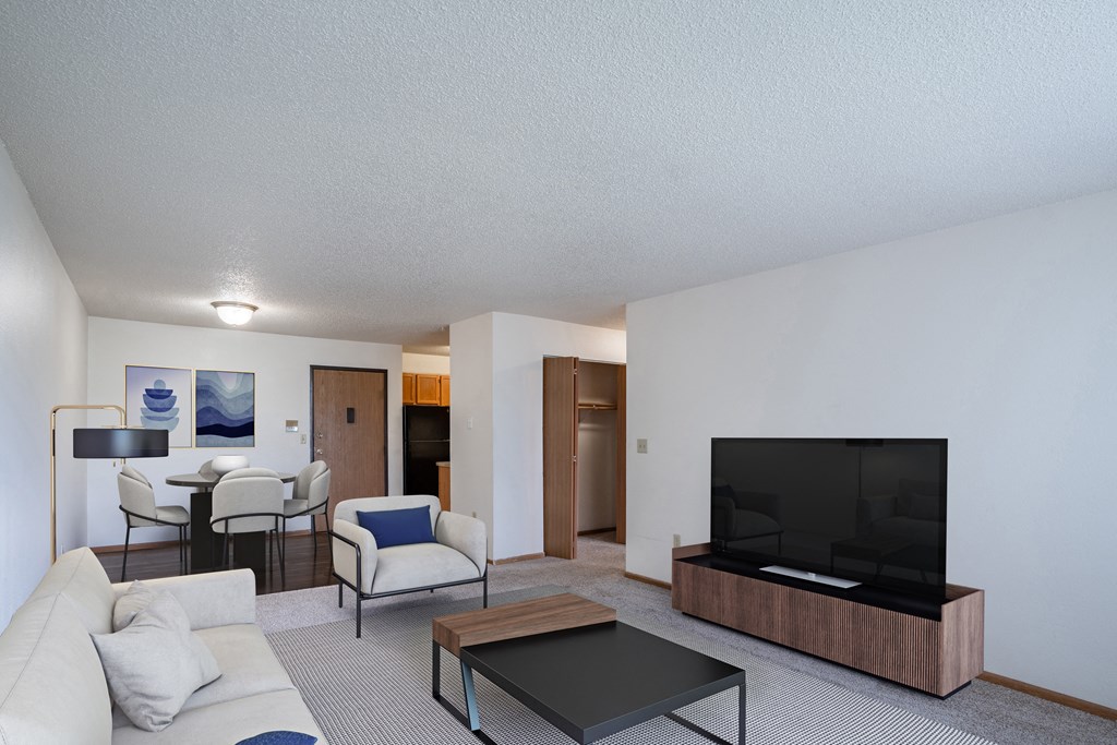 a living room with a couch and a coffee table and a television. Fargo, ND Prairie Park Apartments