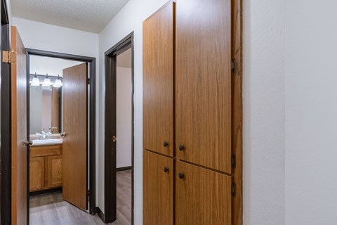 the entrance to a bathroom with two closets and a mirror. Fargo, ND Prairiewood Courts Apartments
