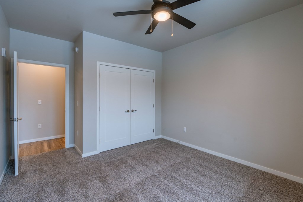 a bedroom with a ceiling fan and a closet. Fargo, ND Prairiewood Meadows