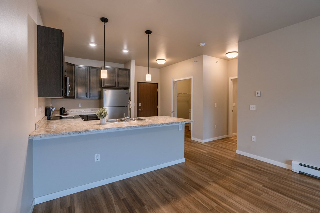 a kitchen and living room with a large island and wood flooring