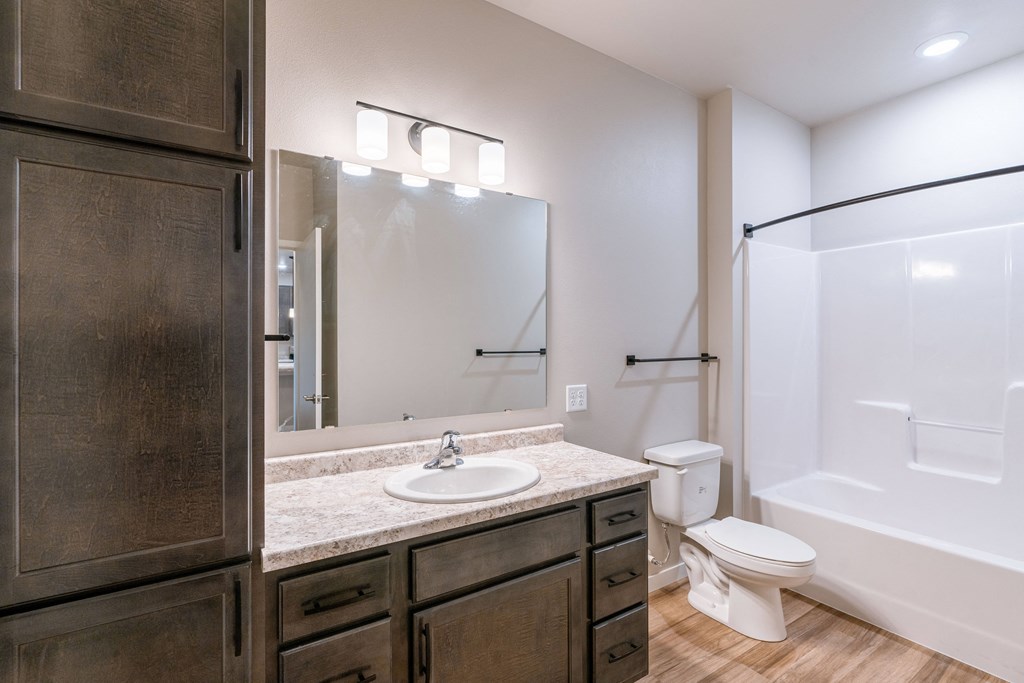 a bathroom with a sink and a toilet and a shower. Fargo, ND Prairiewood Meadows Apartments