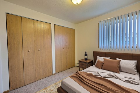 Fargo, ND Saddlebrook Apartments. a bedroom with a bed and two closets