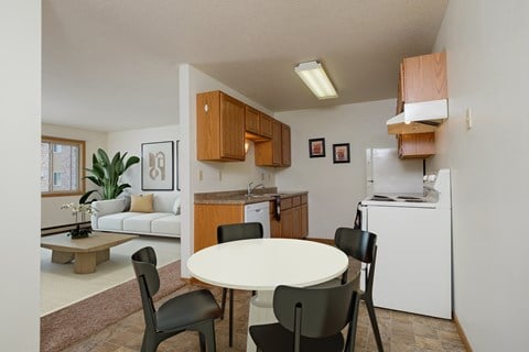 a kitchen and dining room with a white table and chairs. Fargo, ND Sargent Apartments