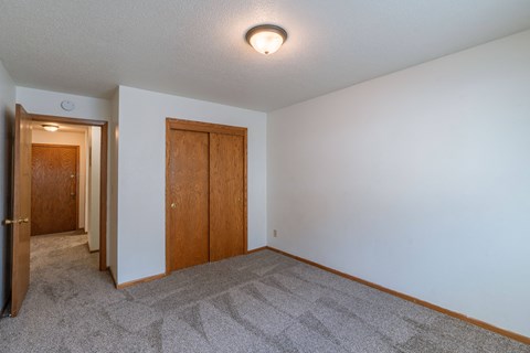 a bedroom with carpet and white walls. Fargo, ND Schrock Apartments