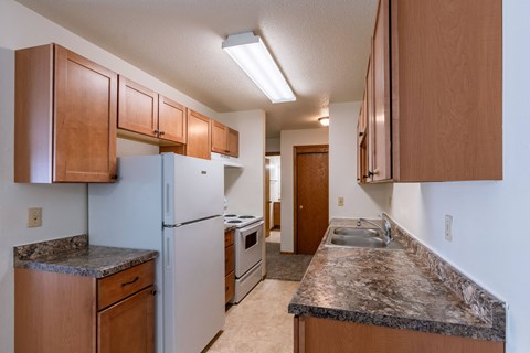 a kitchen with white appliances and granite counter tops. Fargo, ND Schrock Apartments