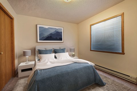 Fargo, ND Somerset Apartments. a bedroom with a large bed and a large window