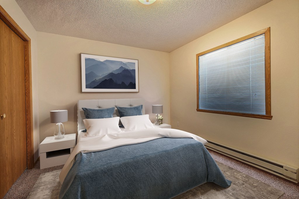 Fargo, ND Somerset Apartments | Bedroom a bedroom with a large bed and a large window. Fargo, ND Somerset Apartments