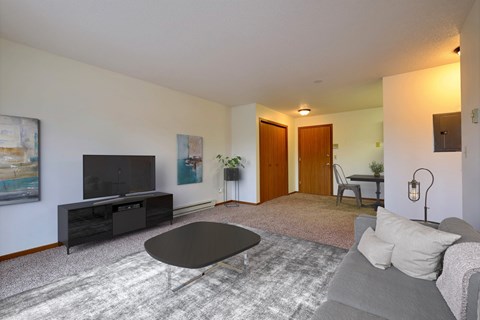 a living room with a couch and a coffee table and a tv. Fargo, ND Southgate Apartments