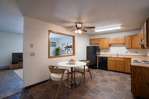 a kitchen and dining area with a white table and chairs