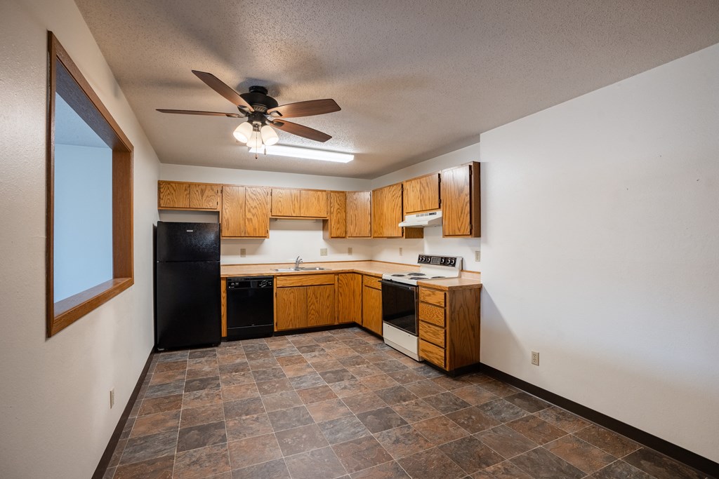 a kitchen with black appliances and tile flooring.  Fargo, ND Southview Village Apartments