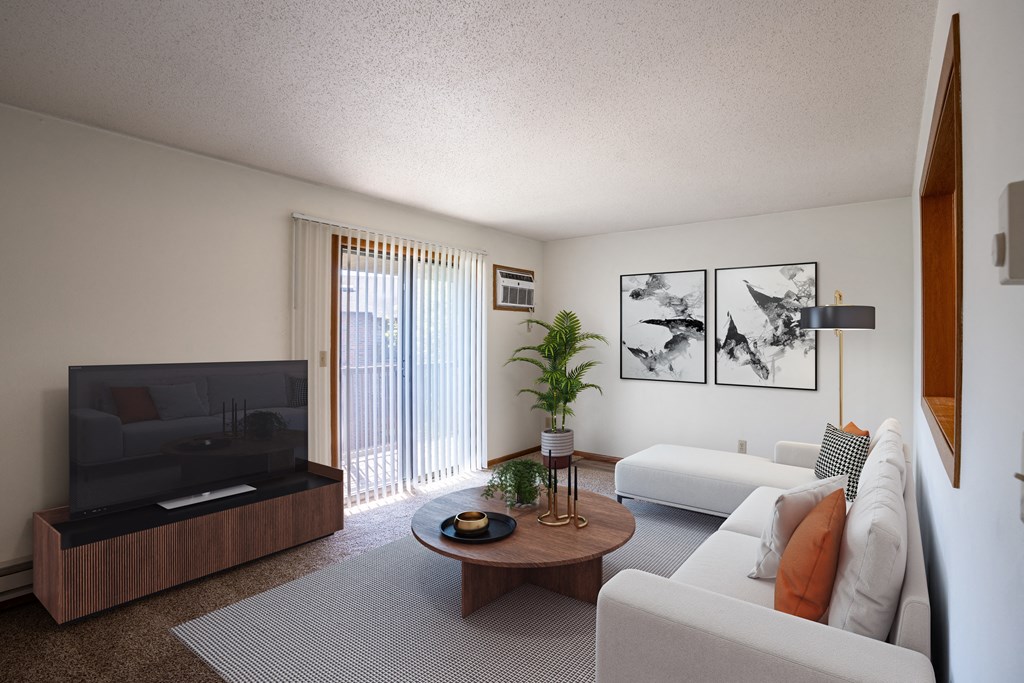 a living room with white furniture and a television. Fargo, ND Southview Village Apartments