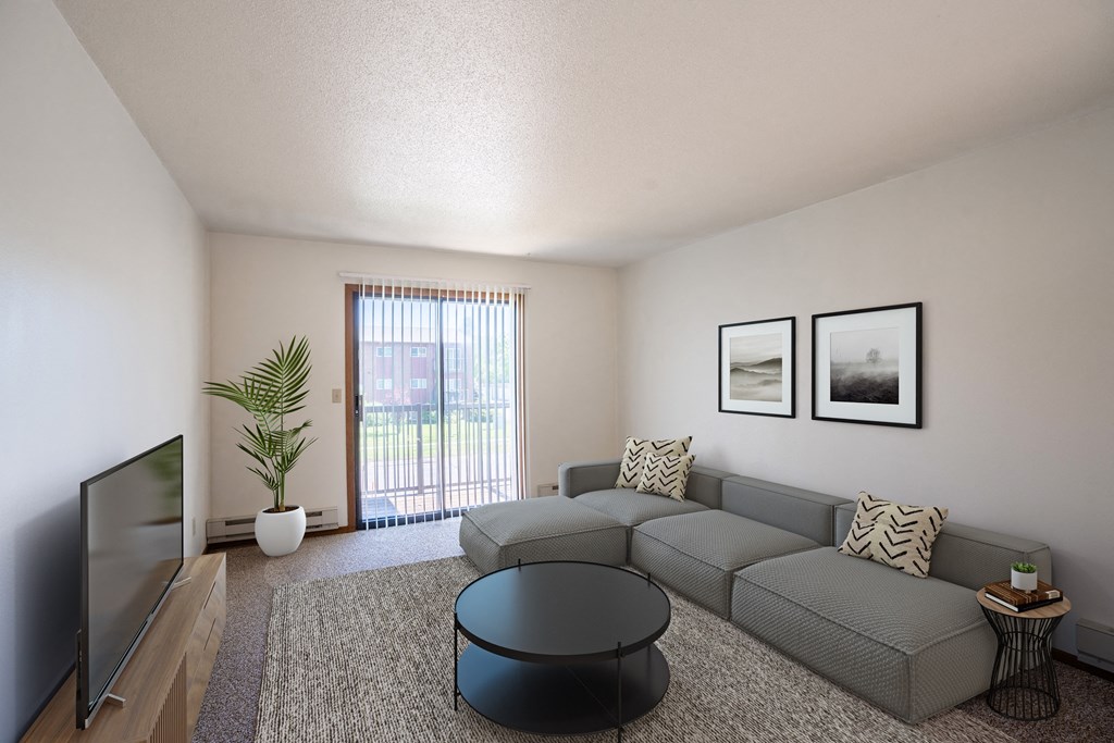 a living room with a gray couch and a tv. Fargo, ND Southview Village Apartments