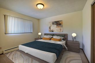 a bedroom with a large bed and a window. Fargo, ND Spring Apartments