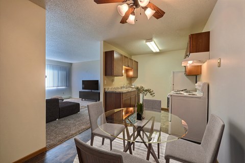 a kitchen and dining room with a glass table and chairs. Fargo, ND Sterling Park Apartments