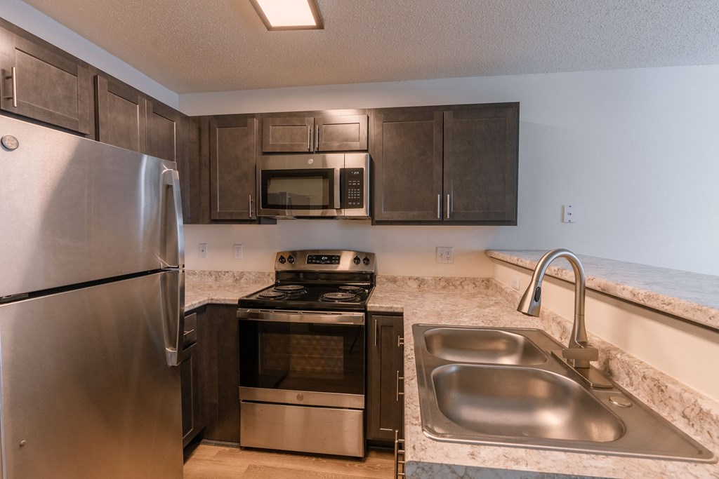 an updated kitchen with stainless steel appliances and granite counter tops. Fargo, ND Sunwood Apartments
