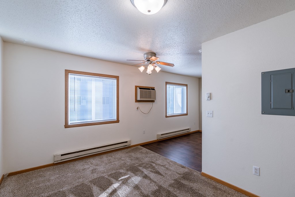 a studio apartment with two windows.  Fargo, ND Sunwood Apartments  | Living and kitchen Fargo, ND Sunwood Apartments