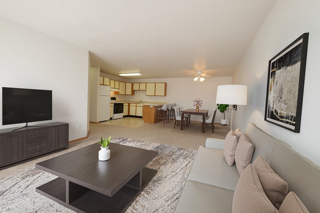 Fargo, ND Thunder Creek Apartments. The room is furnished with comfortable seating, a coffee table, and tasteful decor, creating a warm and inviting atmosphere for relaxation and entertainment. A dining room and kitchen are in the background