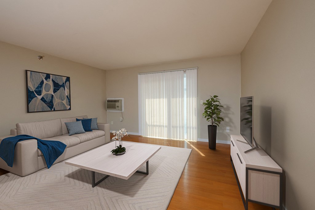 Fargo, ND Thunder Creek Apartments. A living room with a couch, coffee table, tv, and wood flooring.