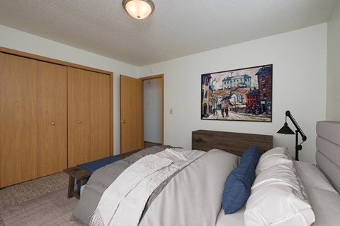 a bedroom with a bed and a couch and a painting on the wall