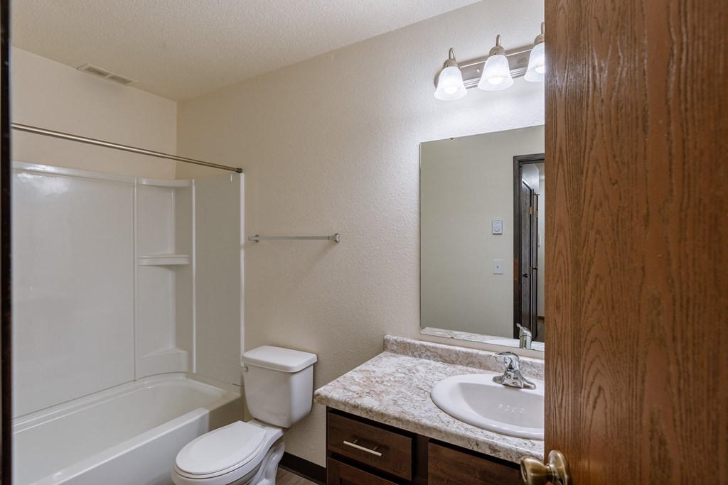 a bathroom with a sink and a toilet and a shower. Fargo, ND Village West Apartments