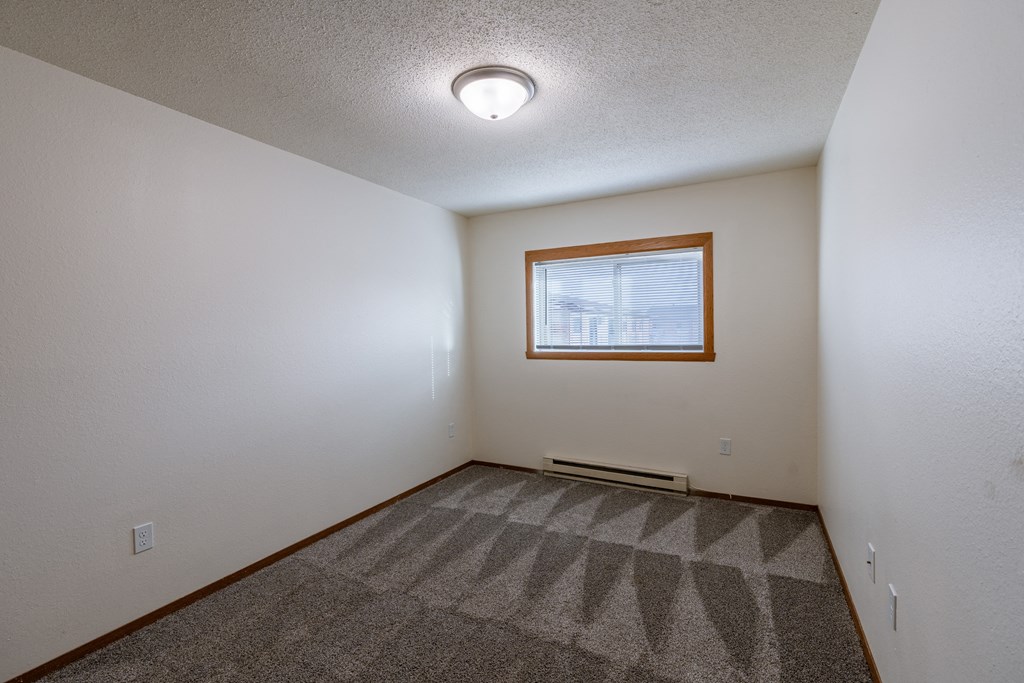 a bedroom with a window. Fargo, ND Village West Apartments