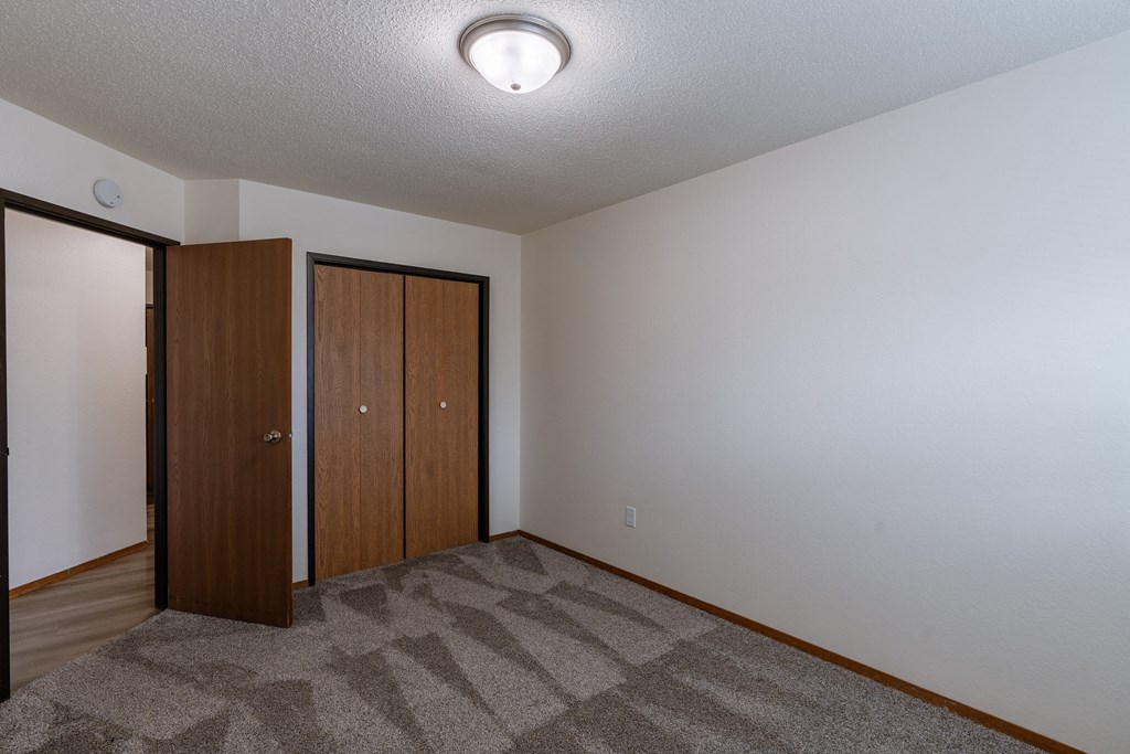 a bedroom with a closet. Fargo, ND Village West Apartment