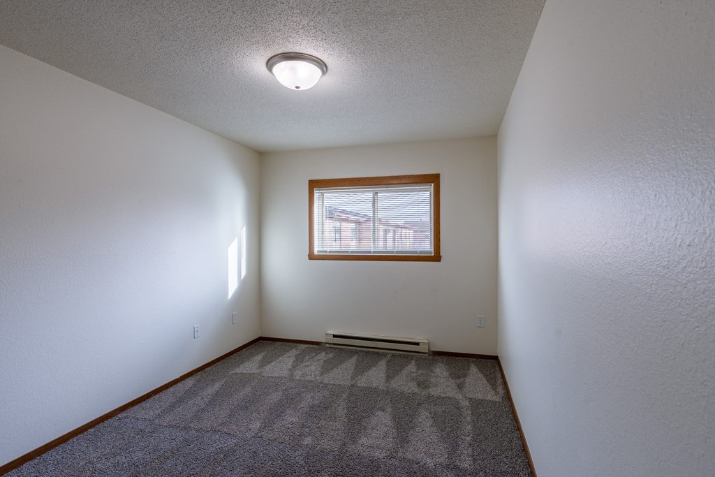 a bedroom with a window. Fargo, ND Village West Apartments