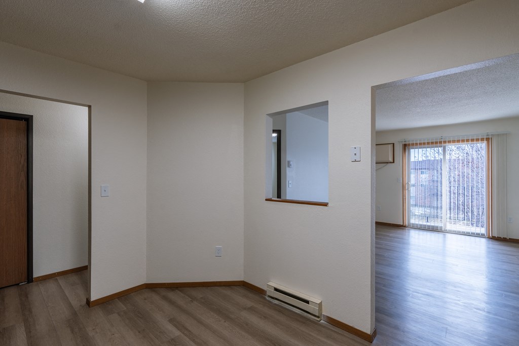 a dining room with a living room in the background. Fargo, ND Village West Apartment