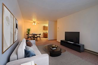 a living room with a couch and a coffee table. Fargo, ND Village West Apartments