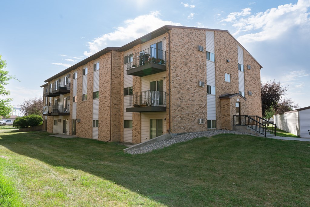 a brick apartment building with balconies. Fargo, ND Village West Apartments