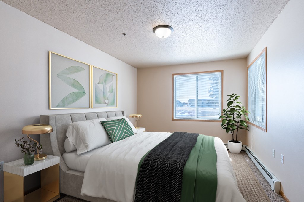 a bedroom with a king sized bed. Fargo, ND West Lake Apartments