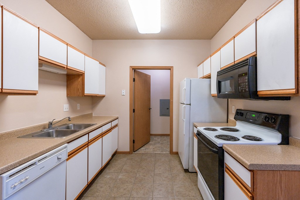 a kitchen with a stove refrigerator and sink. Fargo, ND West Lake Apartments