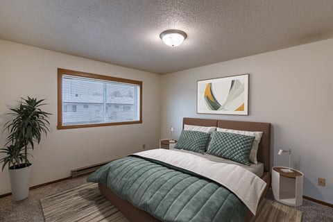 a bedroom with a bed and a potted plant. Fargo, ND West Oak Apartments