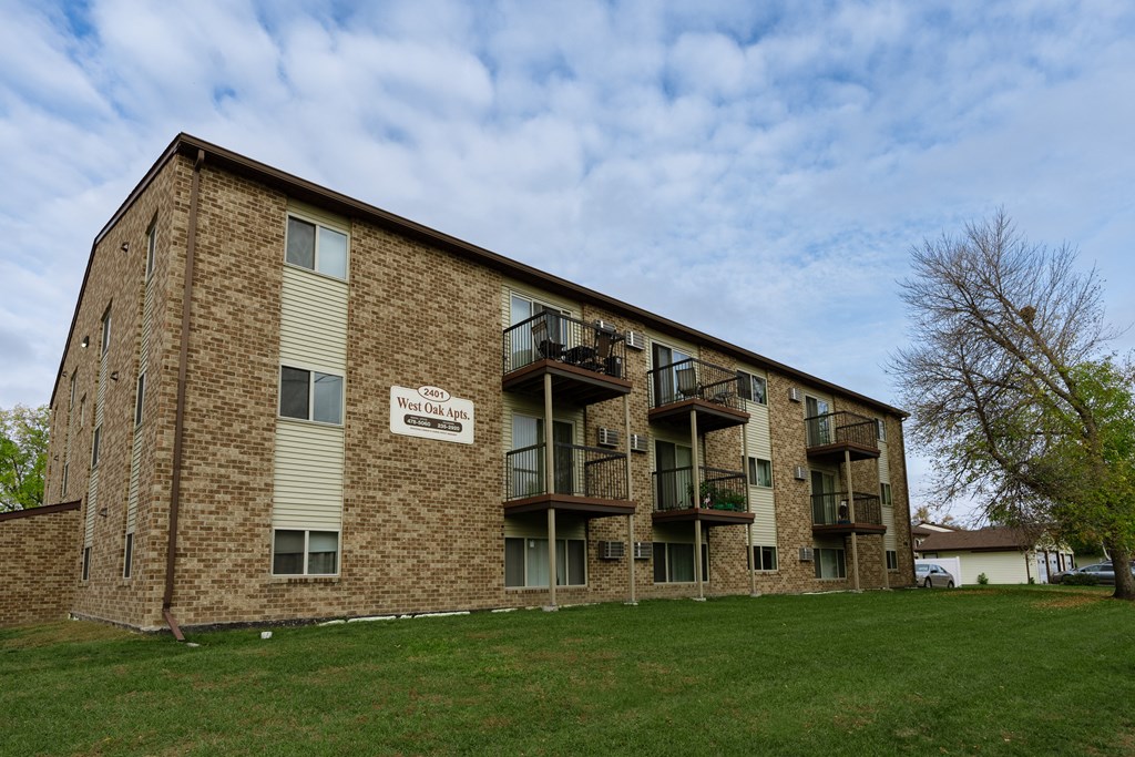 the exterior of a brick apartment building with balconies. Fargo, ND West Oak Apartments.