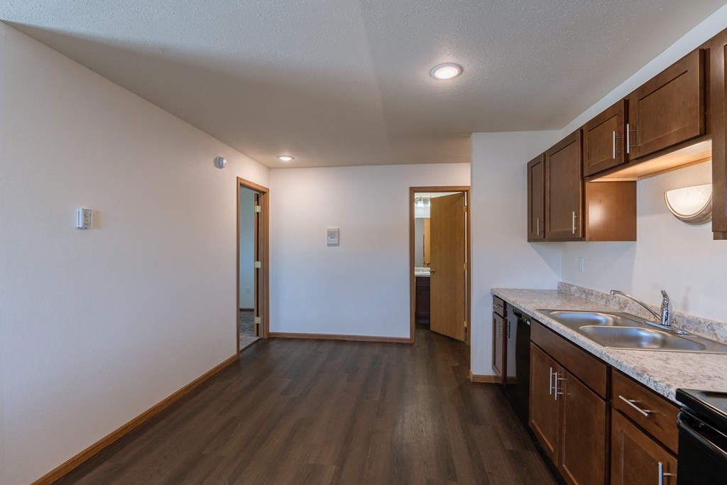 a dining room with a door to a bedroom and bathroom in the background. Fargo, ND Westwood Apartments