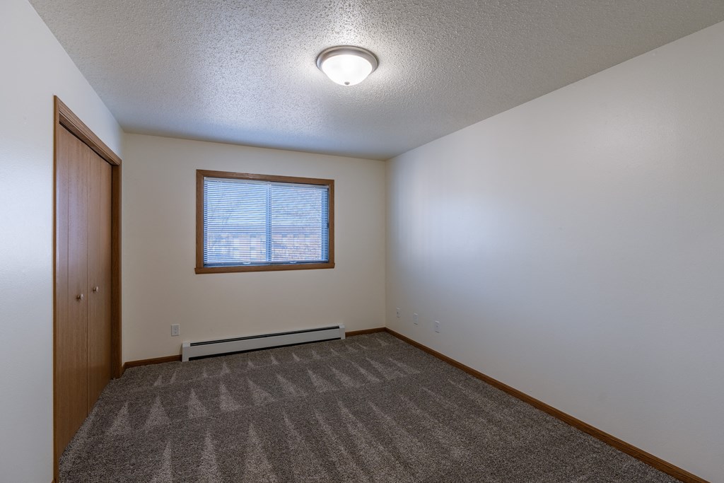 a bedroom with a window and closet. Fargo, ND Westwood Apartments