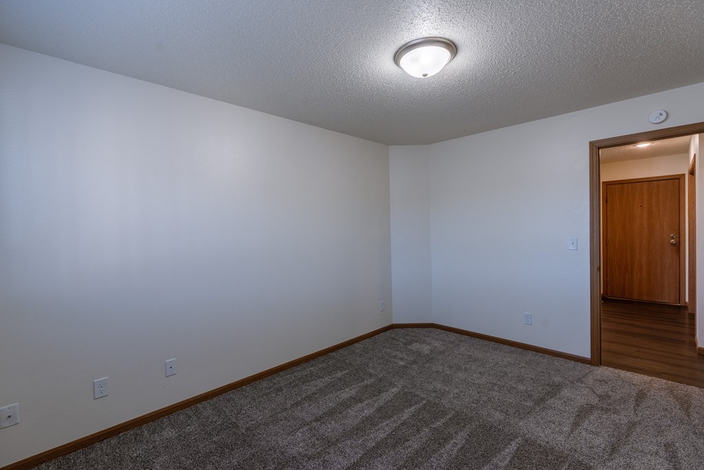 a bedroom with a door to the dining entry area. Fargo, ND Westwood Apartments
