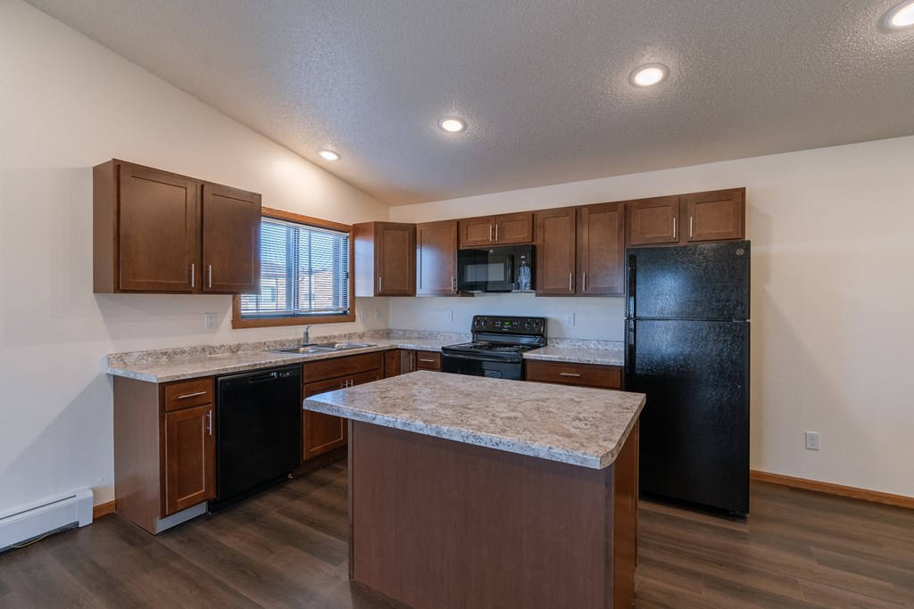 a kitchen with black appliances and white countertops. Fargo, ND Westwood Apartments