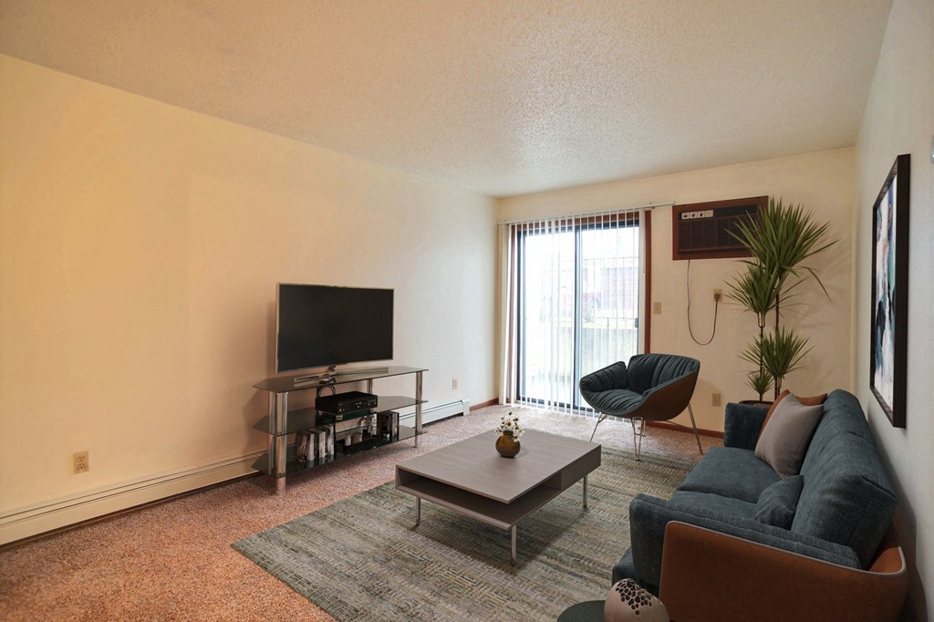 a living room with a couch coffee table and tv. Fargo, ND Westwood Estates Apartments
