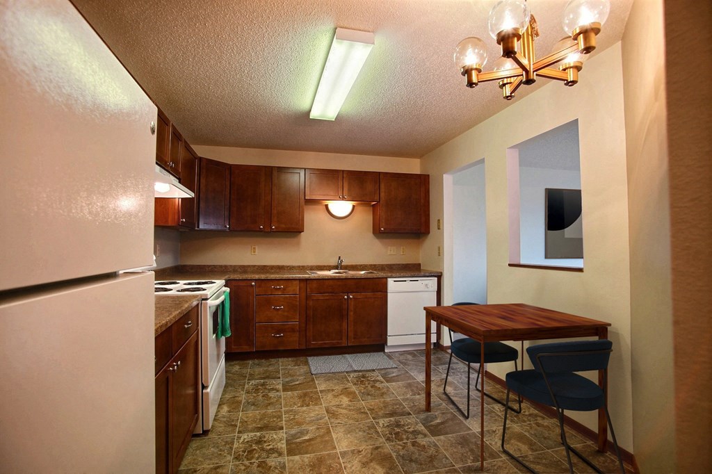 a kitchen with white appliances and wooden cabinets. Fargo, ND Westwood Estates Apartments