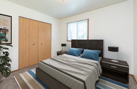 a bedroom with a bed and a closet and a window. Fargo, ND White Ridge Apartments