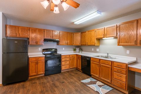 a kitchen with black appliances and white countertops. Fargo, ND Willow Park Apartments